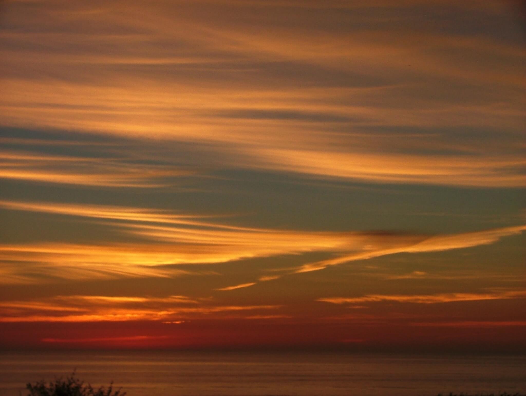 Photograph of colorful cirrus clouds at sunrise.