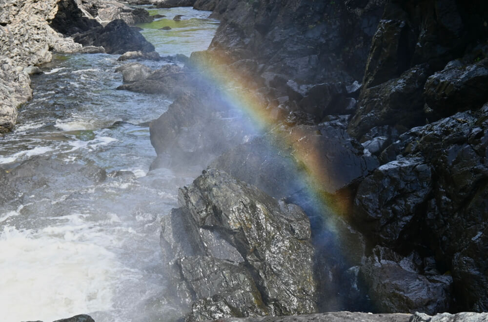 Picture of rainbow created by water flowing from the dam.